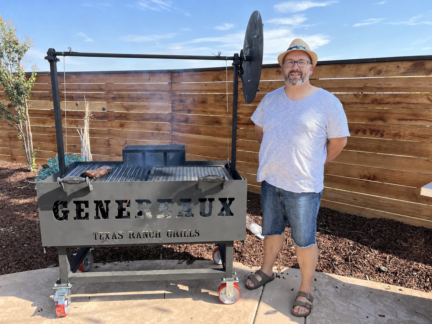 Brad Genereaux standing beside his Santa Maria grill while cooking over live fire